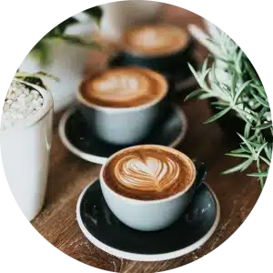Circular image of three espresso coffees on a wooden table.