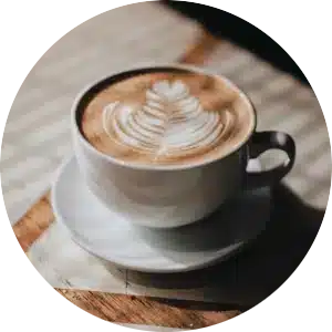 A circular image showcasing a lattes on a table.