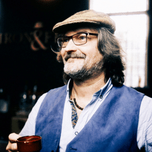 Image of Kev in black and white, looking at a cup of coffee