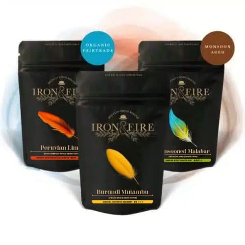 3 black coffee bags arranged in a trio with coloured feather labels on