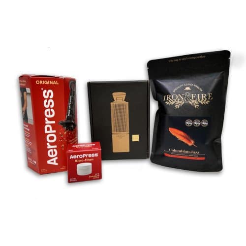 aeropress and filters in a red box with Time More hand grinder in a black box and a black bag of coffee